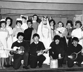 Cast in costume, some nurses uniform with four 'Earwigs', mimicking the Beatles.