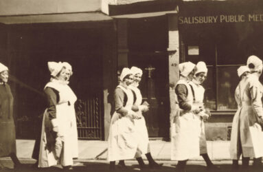Black and white photograph of nurses in 1920 uniforms in a parade