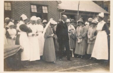 Black and white photo showing nurses in long dress uniforms
