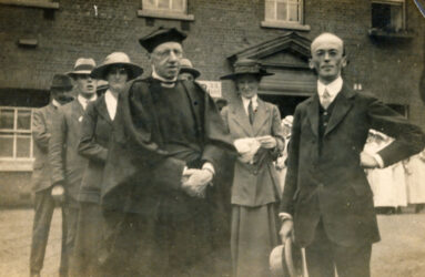 Black and white photograph of people in parade outside Infirmary building
