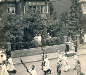 Choristers and medieval dressed characters carrying a model cathedral
