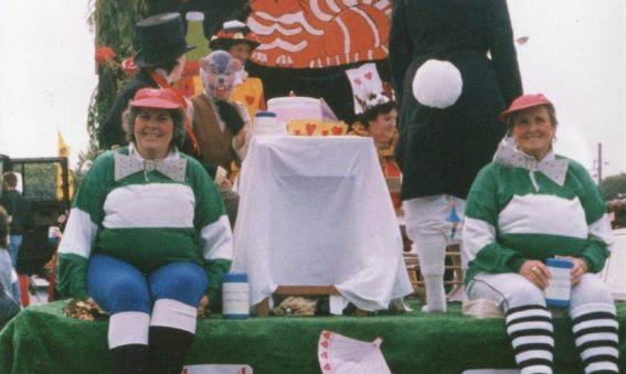 Decorated float with staff dressed as Alice in Wonderland characters
