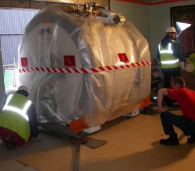 bubble wrapped scanner being wheeled through wall of department