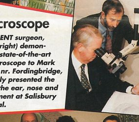 Consultant surgeon looking through microscope at patients ear