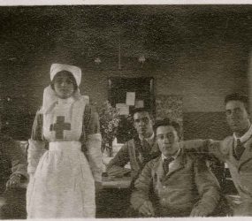 Nurse standing with seated soldiers wearing shirt, tie and jackets