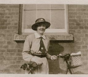 Nurse poses with her bike outside the hospital building