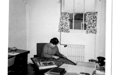 a black and white photo of person doing jigsaw puzzle