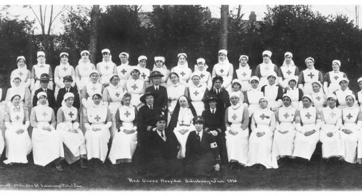 Nurses and other hospital staff seated and standing in rows for photograph