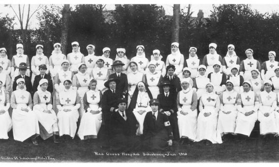 Nurses and other hospital staff seated and standing in rows for photograph