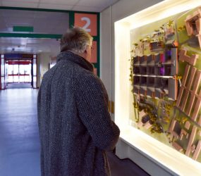 Man looking at model displayed on corridor wall
