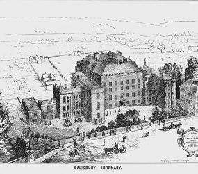View of Infirmary from above, showing street and empty fields surrounding
