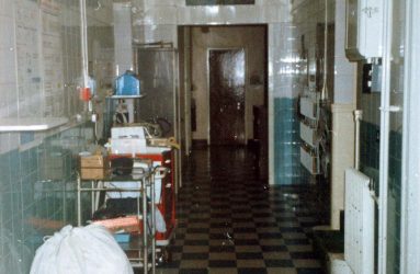 Trolleys, laundry bag and black and white tiled floor in corridor