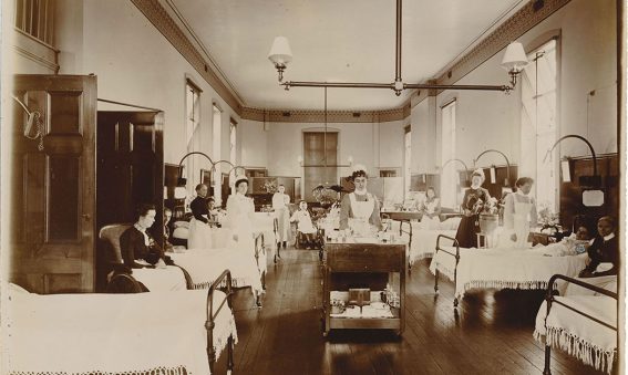 Patients in beds or wheelchairs with nurses attending