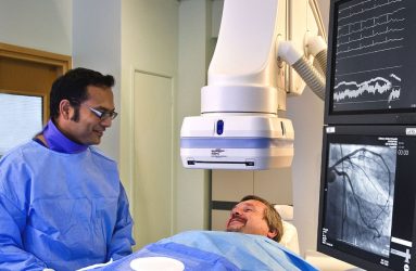 Patient undergoing treatment , digital images of heart on screens