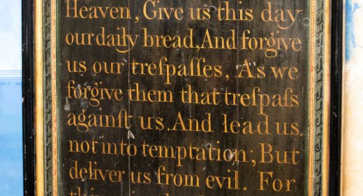 Oak panel arch shape with hand written lettering of Lord's prayer