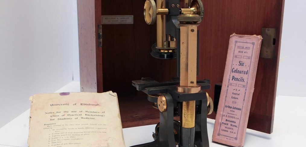 1920s metal optical microscope with wooden box, University of Edinburgh notes and pack of six coloured pencils in pink box