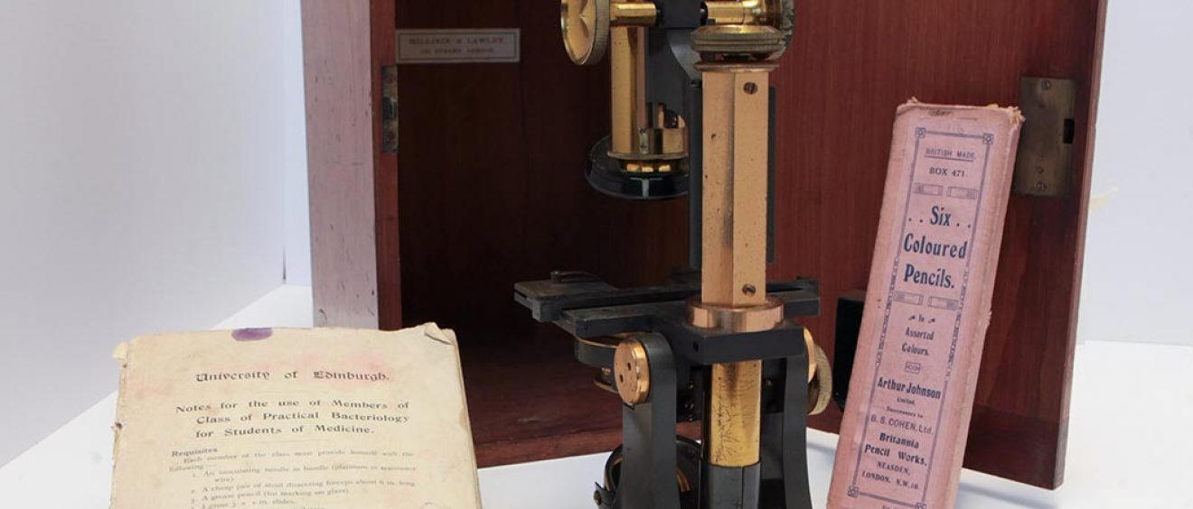 1920s metal optical microscope with wooden box, University of Edinburgh notes and pack of six coloured pencils in pink box