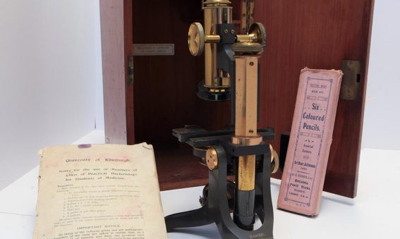1920s metal optical microscope with wooden box, University of Edinburgh notes and pack of six coloured pencils in pink box