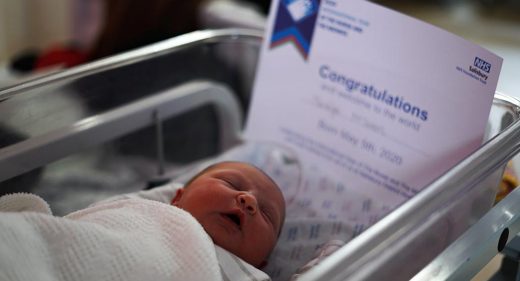 newborn baby in cot with certificate