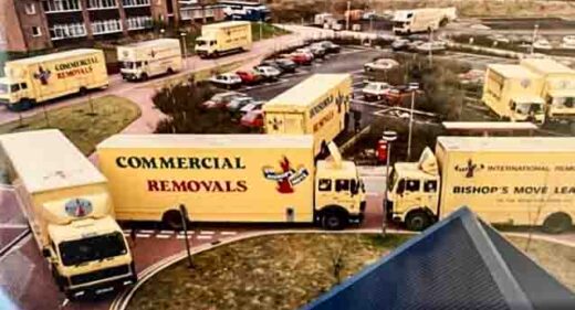 fleet of removal vans outside main entrance of new hospital building