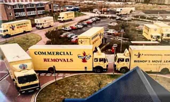 fleet of removal vans outside main entrance of new hospital building