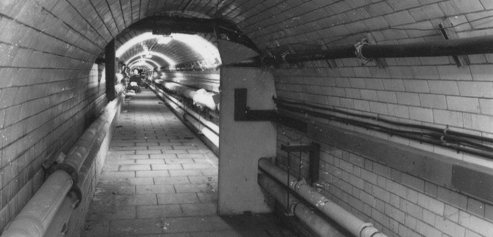 tiled tunnel with pipework visible