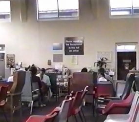 Rows of chairs in Outpatients Hall, plaque visible on reception wall