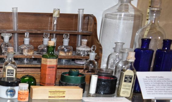 clear glass bottles and green and blue hexagonal glass bottles with stoppers