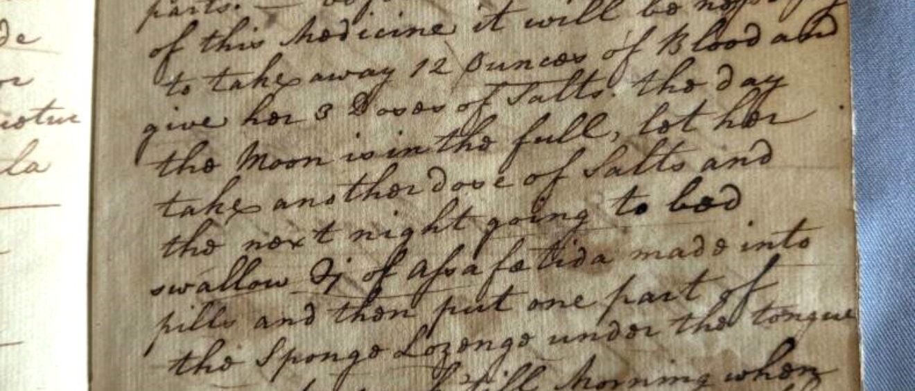 colour photograph of historic prescription book, with ink handwriting
