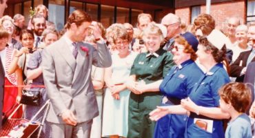 Prince Charles standing with crowds of staff and patients outside Spinal Unit entrance