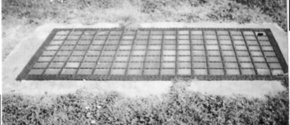 Black and white photo of grating in ground